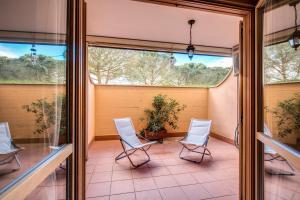 Inn Bracciano Suite Casa Vacanze في براتشيانو: شرفة مفتوحة مع كرسيين ونافذة