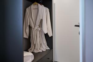 a robe hanging on a rack in a closet at REGINA Bed&Wine in Varna City +109 photos