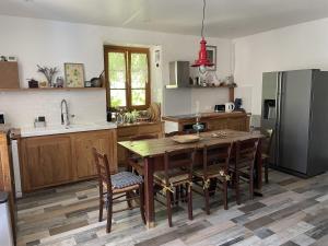 a kitchen with a wooden table and a refrigerator at Chateau Cottage in Carlux