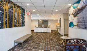 a waiting room with a table and chairs and paintings on the wall at The Kenilworth Hotel - Airport West in Kenilworth +29 photos