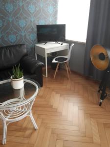 a living room with a couch and a desk at Landhotel zur guten Quelle in Eisenach