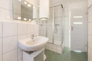 a white bathroom with a sink and a shower at Ferienwohnung Strandliebe in Koserow +20 photos