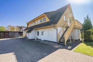 a house with a gambrel roof and a driveway at Ferienwohnung Strandliebe in Koserow