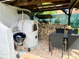 a patio with a pizza oven and a table and chairs at Zselic Kuckó by Mártika in Szigetvár