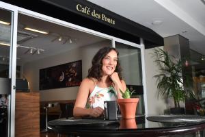 a woman sitting at a table in a restaurant at Mar Hotel Conventions in Recife +99 photos