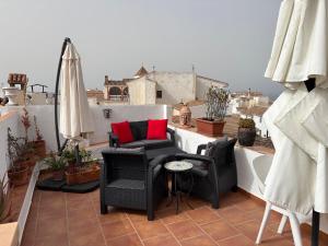 a balcony with chairs and tables on a roof at La Vieja Botica in Canillas de Aceituno