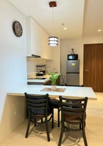 a kitchen with a table and two chairs and a clock at Go Q Tambuli Seaside Studio in Maribago