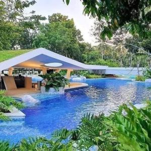 a house with a large pool of blue water at Go Q Tambuli Seaside Studio in Maribago