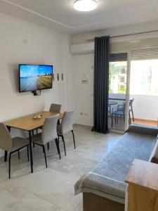 a living room with a table and chairs and a tv at Beachfront Apartment Durres in Durrës