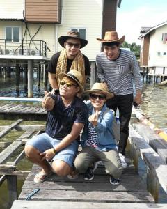 a group of men wearing hats standing on a dock at Kunyit 7 Lodge in Bandar Seri Begawan