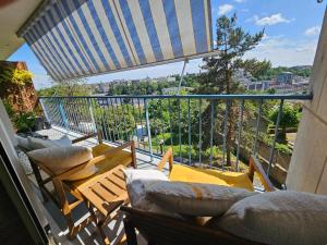 a balcony with chairs and a table and an umbrella at Jasmin Doux in Poitiers