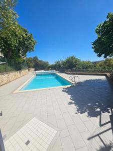 a swimming pool on a tiled patio with a blue at Jasmin Doux in Poitiers