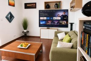 a living room with a couch and a tv at Casa Mangrove in Maputo