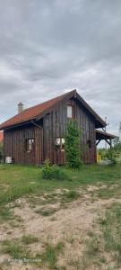 a large wooden barn sitting on top of a field at Chata pod kogutem in Barczewko