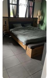 a bed with a wooden frame in a bedroom at La coconing in Vierzon