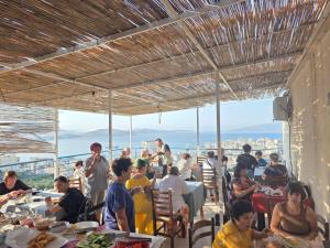 a group of people sitting at tables in a restaurant at León Hotel Saranda in Sarandë