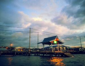 a dock with a gas station on the water at Kunyit 7 Lodge in Bandar Seri Begawan