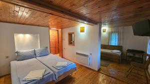 a bedroom with a bed and a television in a room at Къща за гости Хитър Петър in Apriltsi +133 photos