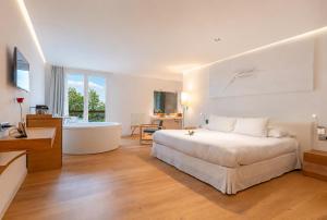 a bedroom with a large bed and a bath tub at Arantza Hotela - Boutique Hotel "Adults Only" in Arantza