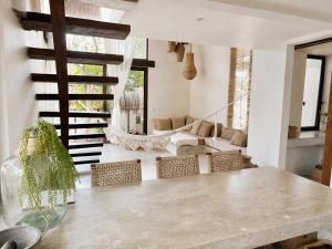 a living room with a large table and chairs at Ikal Bungalows Tulum in Tulum