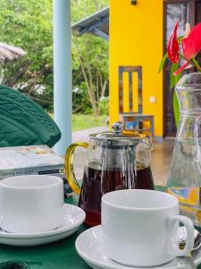 a tea pot and two cups on a table at Turtle Breeze Rekawa in Tangalle +20 photos