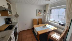 a small kitchen with a table and a window at Ferienwohnung Inge EG in Greetsiel