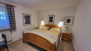 a bedroom with a wooden bed in a room at Ferienwohnung Inge EG in Greetsiel