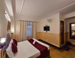 a hotel room with a bed and a television at The Baris Haridwar in Haridwār