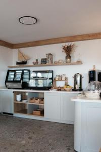 a kitchen with white cabinets and a counter at Pansion Jakas in Zavala