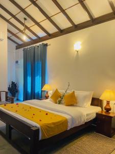a bedroom with a large bed with yellow sheets at Turtle Breeze Rekawa in Tangalle