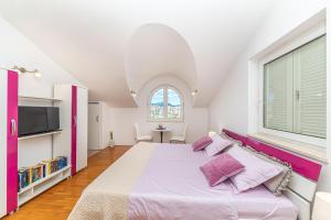 a bedroom with a large bed and a window at Apartmani Villa Biočić in Split