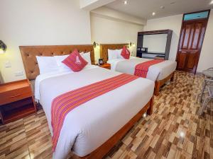 a hotel room with two beds and a mirror at Hotel Sky Mirador in Cusco +29 photos