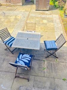 two chairs and a white table and chairs on a patio at Contractors , holiday house, free parking , sleeps 5 in Knowsley