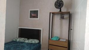 a bedroom with a bed and a clock on the wall at Kitnet Encanto Astral in São Thomé das Letras