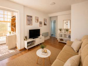 a living room with a couch and a tv at Abuela Maruja - Piso acogedor en Cee, perfecto para desconectar in Cee