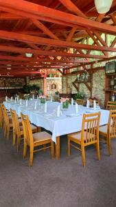 ein langer Tisch mit weißen Tischen und Stühlen in der Unterkunft Grace Villa in Codru