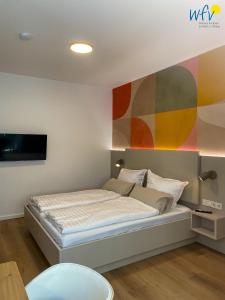 a bedroom with a bed with a painting on the wall at Stine's Hus Ferienwohnung 1 in Borkum