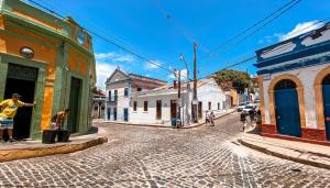 a group of people walking down a cobblestone street at Hostel 4 Cantos in Olinda