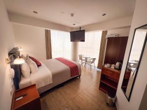 a hotel room with a bed and a table at Hotel Sky Mirador in Cusco