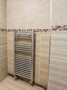 a shower with a metal door in a bathroom at Aron Guest House in Ealing +28 photos