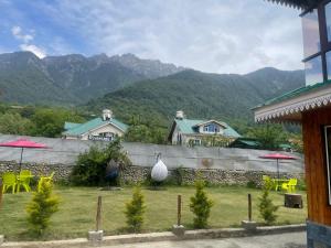 a yard with tables and chairs and mountains in the background at The Mountain Suites in Batakūt