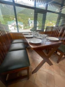 a dining room table with chairs and a large window at The Mountain Suites in Batakūt