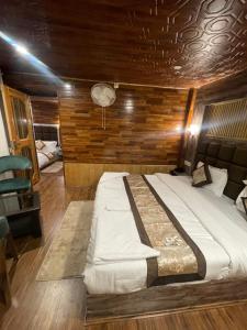 a large bed in a room with a wooden wall at The Mountain Suites in Batakūt