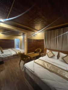 a hotel room with two beds and a table at The Mountain Suites in Batakūt