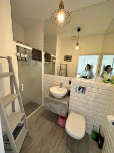 a woman taking a picture of a bathroom at Przystań Dębki in Dębki
