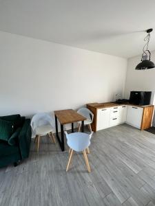 a living room with a couch and a table and chairs at Przystań Dębki in Dębki +3 photos