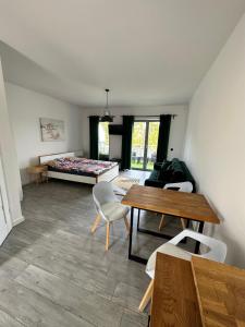 a room with a bed and a table and chairs at Przystań Dębki in Dębki