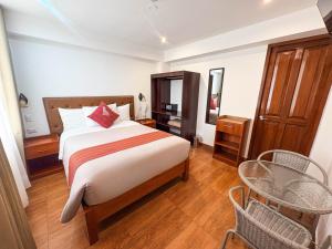 a bedroom with a bed and a table and chairs at Hotel Sky Mirador in Cusco