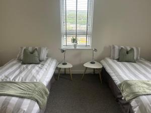 two twin beds in a room with a window at Kilnhill in Hawick