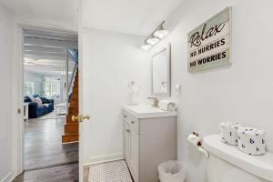 a white bathroom with a sink and a mirror at Long Sands Serenity in York +40 photos